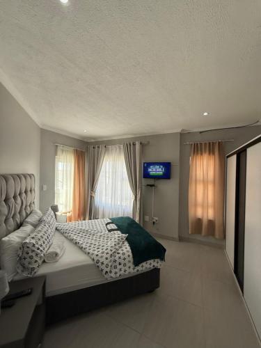 Un dormitorio con una cama y un televisor. en Unit 32 Ongwe, en Swakopmund