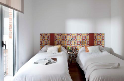two beds sitting next to each other in a room at Eric Vökel Boutique Apartments - Madrid Suites in Madrid