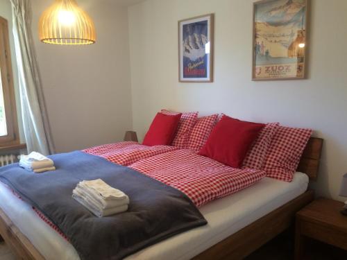 a bedroom with a bed with red and white pillows at Chesa Muragls in Pontresina