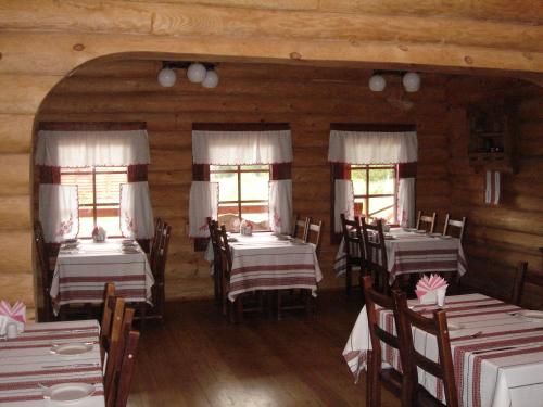 a dining room with tables and chairs and windows at Solovki Hotel in Solovetsky Islands