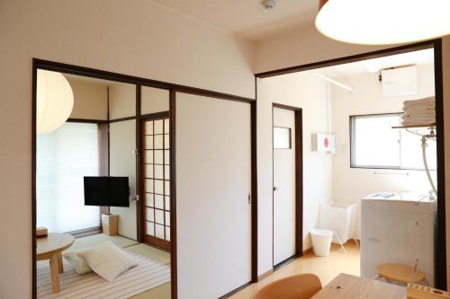 a room with sliding glass doors and a living room at MINI HOTEL totonoi ロウリュ式サウナのある静かな平屋 in Shimonoseki