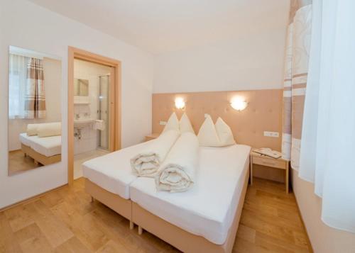 a large white bed in a room with a mirror at Apart Alexandra in Ischgl