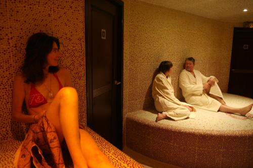 EXIGEHOME-Large houseboat with spa near Paris في سان-كلو: مجموعة من الناس يجلسون على الأسرة في غرفة