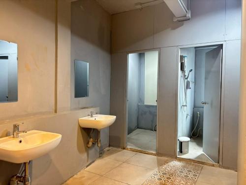 a bathroom with two sinks and a shower at Sukhum Huai Khwang Guest House in Bangkok