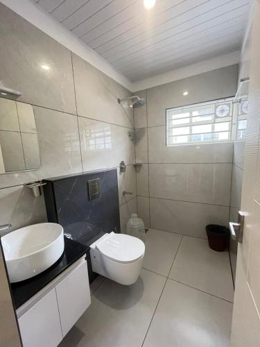 a bathroom with a white toilet and a sink at Aagneyam Grand Resort in Kozhikode
