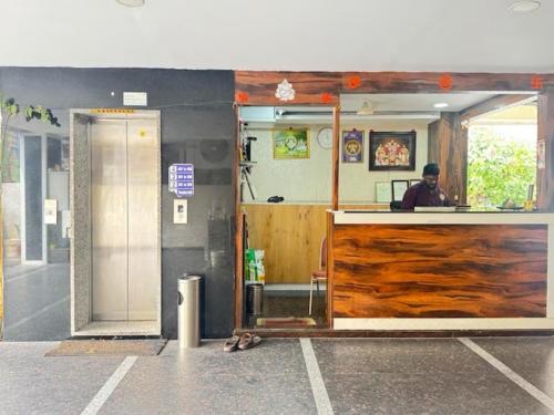a man sitting at the counter of a restaurant at Hotel Sri Hasmitha in Vijayawāda