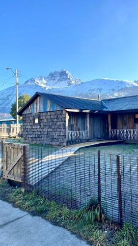 a house with a fence in front of it at Fully renovated cabin in Villa Cerro Castillo, Patagonia in Villa Cerro Castillo