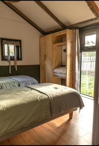 a bedroom with two beds and a window at Fully renovated cabin in Villa Cerro Castillo, Patagonia in Villa Cerro Castillo