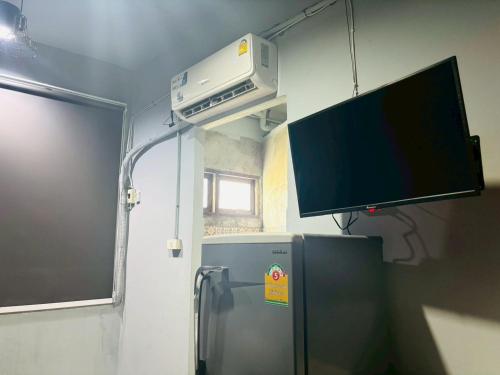 a room with a tv and a refrigerator at Sukhum Huai Khwang Guest House in Bangkok