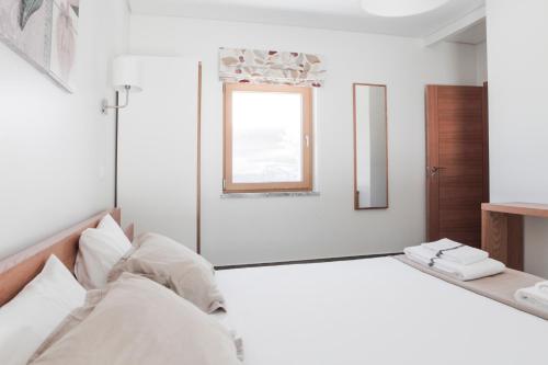 a mirror in a white room with a bed at Monte Girassol - The Lisbon Country House in Quinta das Faias