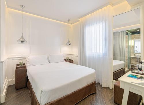 a hotel room with two beds and a large window at H10 Universitat in Barcelona