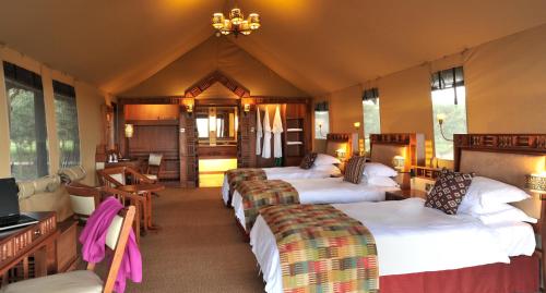 a hotel room with four beds in a room at Sweetwaters Serena Camp in Nanyuki