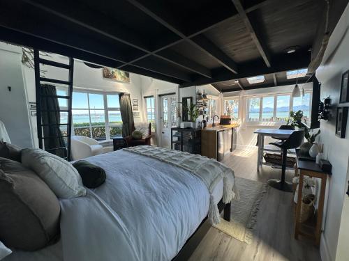 a bedroom with a large bed in a room with a desk at The Point Studio in Nelson
