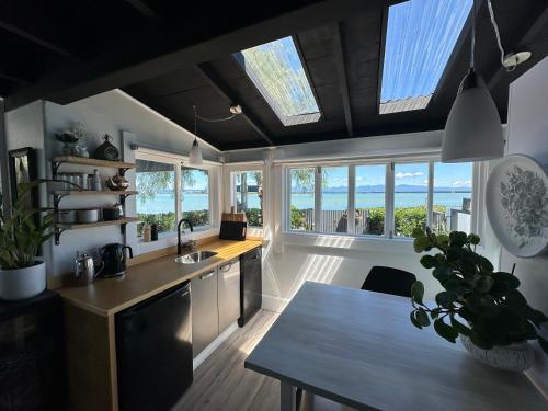 a kitchen with a sink and a counter with windows at The Point Studio in Nelson