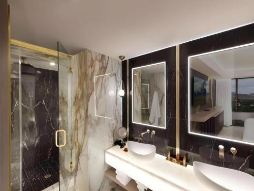 a bathroom with two sinks and a shower at Peppermill Resort Spa Casino in Reno