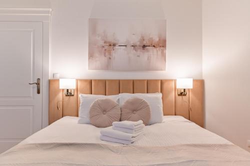 a bedroom with a bed with towels on it at Szeroka Residences in Toruń