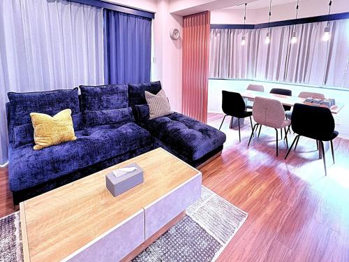a living room with a blue couch and a table at Spacious Family Stay Shinagawa-Kokoro House in Tokyo