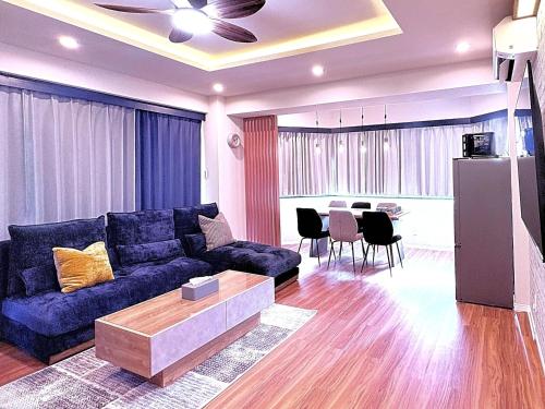 a living room with a blue couch and a table at Spacious Family Stay Shinagawa-Kokoro House in Tokyo