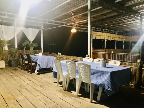 a group of tables and chairs with blue table cloth at Kthorm Nesat Koh Kong in Phumĭ Stœ̆ng Vêng