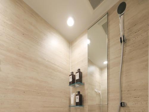 a bathroom with a shower with two bottles on the wall at Oizumigakuen House in Yagisawa