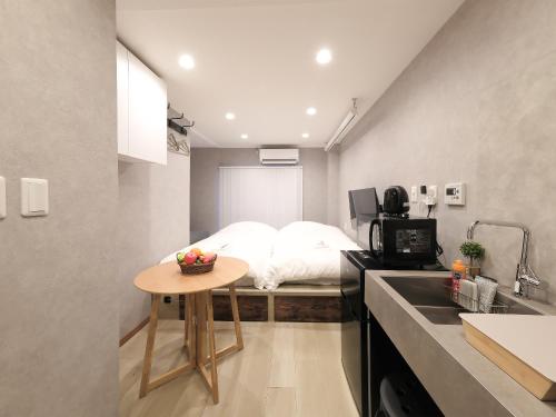 a room with a bed and a table with a bowl of fruit on it at Oizumigakuen House in Yagisawa