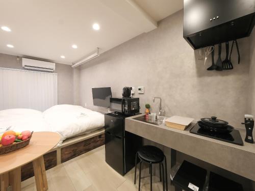 a small room with a bed and a kitchen at Oizumigakuen House in Yagisawa