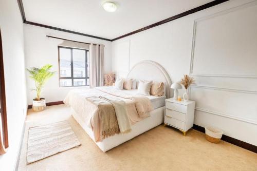 une chambre blanche avec un grand lit et une fenêtre dans l'établissement Tropical Oasis-Luxury Apartment, à Trevallyn