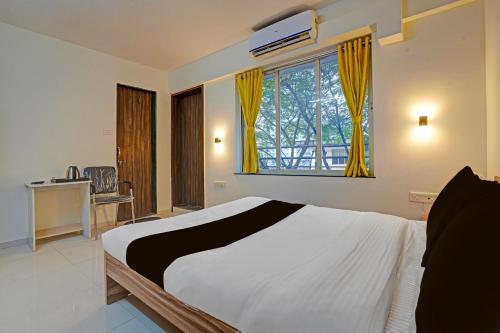 a bedroom with a bed and a window with yellow curtains at Collection O Baner Hillview Pune Formerly Siri Lodge in Méribel Village