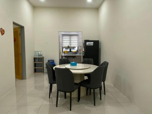 comedor con mesa, sillas y nevera en 96 HomeStay Sungai Besar, en Sungai Besar