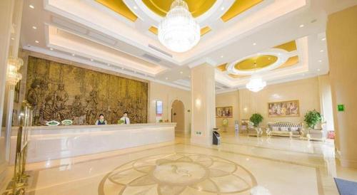 Vienna Classic Hotel Qingyuan Taihe Ancient Cave Scenic Area في Xiaoshi: لوبي كبير وعليه لوحة كبيرة على الحائط