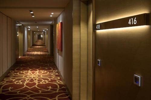 a corridor of a hotel with a long hallway at Feathers- A Radha Hotel, Chennai in Chennai