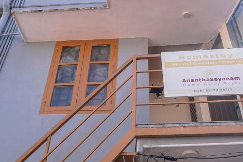 a sign on the side of a building with a window at AnanthaSayanam Homestay Near Sri Padmanabha Swamy Temple in Trivandrum