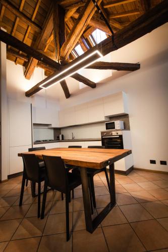 a large kitchen with a wooden table and chairs at Penthouse at the Monument in Trichiana