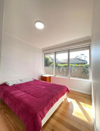 a white bedroom with a bed and a window at Budget-friendly room near Sunshine Station to CBD in Sunshine