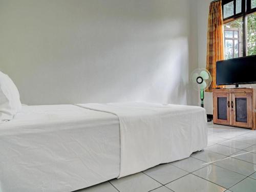 Ένα ή περισσότερα κρεβάτια σε δωμάτιο στο Hotel O Home Stay Syariah Aom Kusman