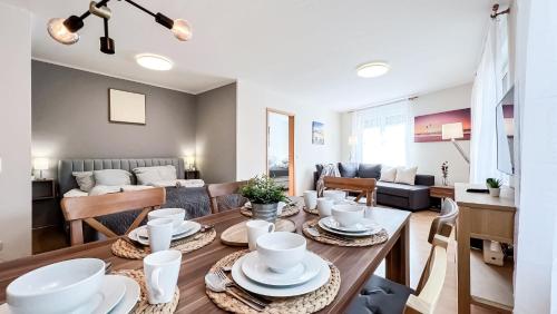 a dining room and living room with a table and chairs at Ferienwohnung in der Stadt mit kostenfreier Tiefgarage bis 1,50m Fahrzeughöhe - 2 Doppelbetten, Küche, Bad in Leipzig