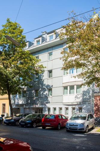 a large white building with cars parked in front of it at Residenz Donaucity in Vienna