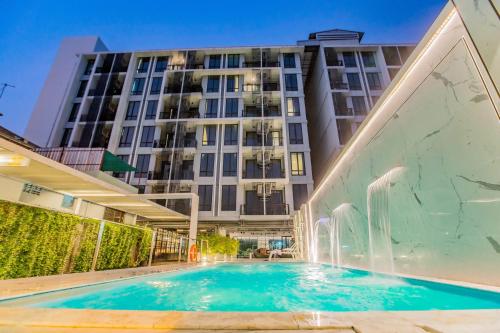a swimming pool in front of a building at Marigold Sukhumvit - Free Shuttle to BTS Bearing Station in Bangkok