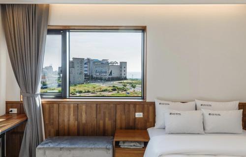 群山市Gunsan LAONHAJE的一间卧室，里面有一张床和一扇大窗户。