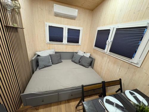 a small bed in a room with two windows at KE-Tiny- Siedlung Haus Paulchen in Oerlenbach