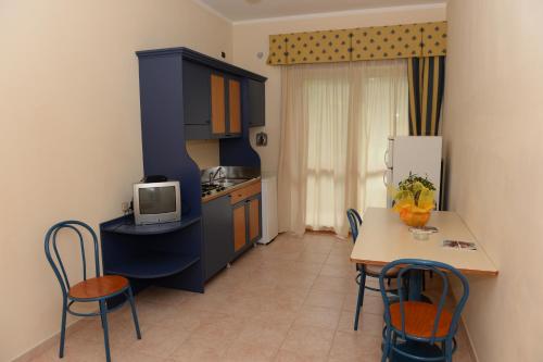 a small kitchen with a table and a refrigerator at Casa Vacanze Oasi Felicita in Nova Siri Marina