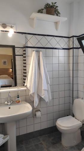 a bathroom with a sink and a toilet and towels at Donatos Parga - Apartments & Studios in Parga