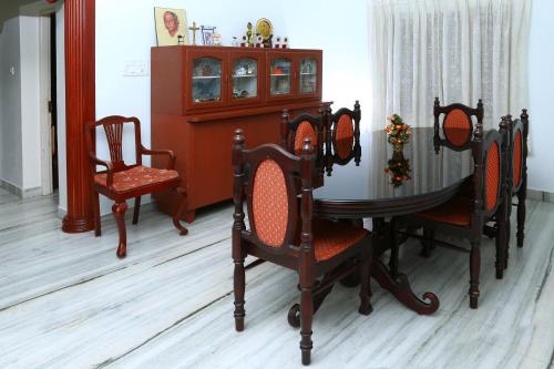 a room with a table and chairs and a cabinet at Casa Mia Homestay in Cochin