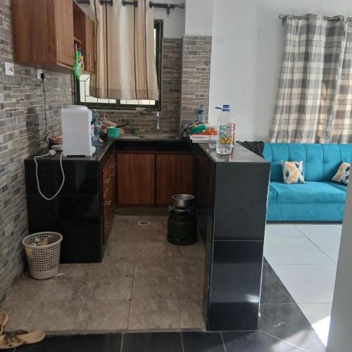 a kitchen and living room with a blue couch at Mikes apartment in Mombasa