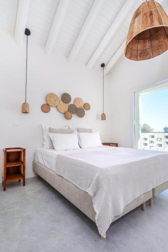 a white bedroom with a large bed and a large window at La Réserve-Comporta by Terresens in Comporta