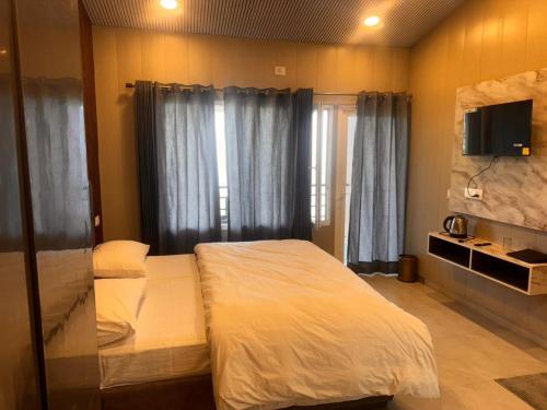 En eller flere senge i et værelse på Dhanaulti The Grand Resort