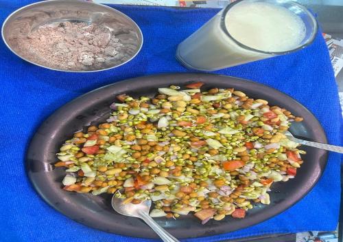 a pan of food on a table with a bowl of food at Akshay premium suites1 BHK Serviced Apartments Near Artemis Hospital Sector 52 in Gurgaon