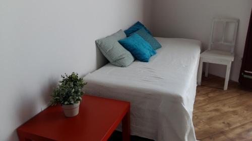 1 cama pequeña con almohadas azules y mesa roja en L'affresco, en La Spezia