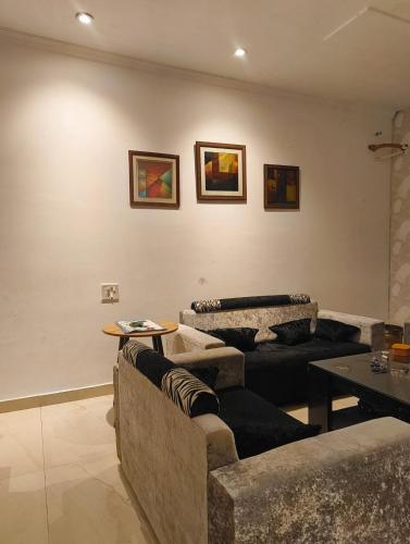 a living room with two couches and a table at Quiet Haven in Panchkula