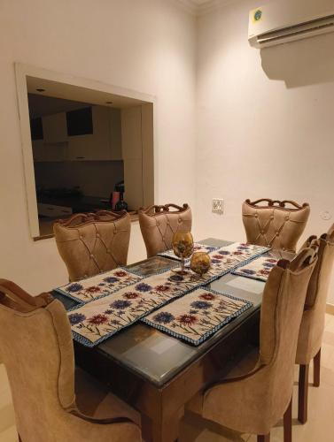 a dining room with a table with chairs and a mirror at Quiet Haven in Panchkula